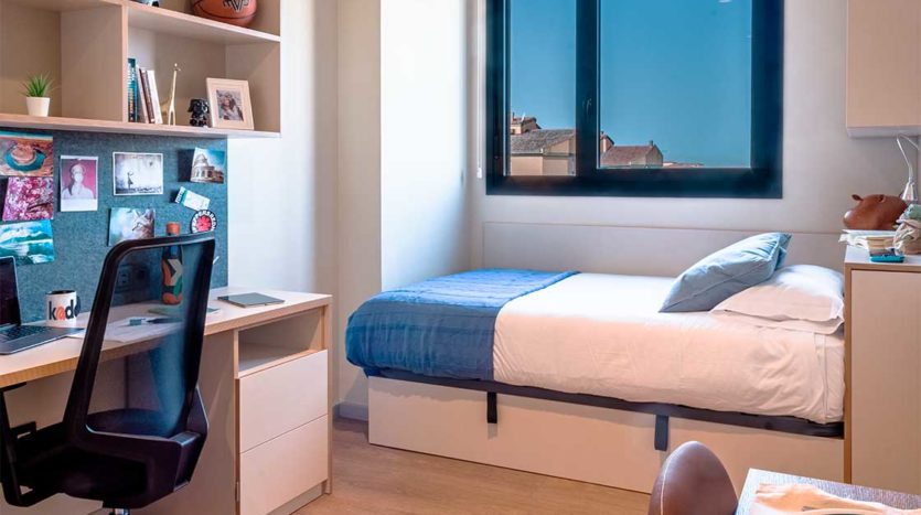 Residecia Universitaria Kadora Granada Cama y escirotio en habitación